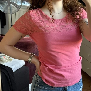 Rosa spetsdetaljerad topp  - Super cute pink top from H&M Conscious Collection with lace over the shoulders and chest. Short sleeves and a figure-hugging fit, perfect with jeans or a skirt. Soft and comfortable, with nice lace details that give a cute touch.