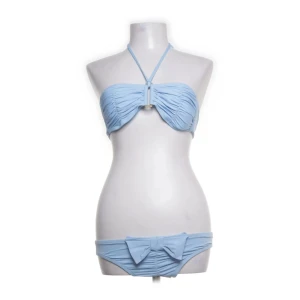 Ljusblå bikini  - Söt ljusblå bikini från L*Space med bandeau-topp och halterneckband. Bikinitrosan har en dekorativ rosett baktill och lätt rynkade detaljer på både över- och underdel. Perfekt för sommardagar vid stranden. Storlek saknas men skulle säga S eller M. Setet för 500 kr, eller vardera för 300 kr. 