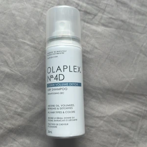 Olaplex  torr shampo - Olaplex No.4D Clean Volume Detox är ett torrschampo i sprayform som absorberar olja, ger volym och fräschar upp håret. Passar alla hårtyper och färger. Kommer i en vit flaska med blå detaljer och genomskinligt lock, 50 ml.