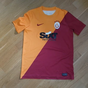 Galatasaray Hemmatröja 21/22 - Säljer en Galatasaray Hemmatröja från säsongen 21/22 då jag vuxit ur den.                        Den är en orginell tröja från nike som är i mycket bra skick och den perfekt för fotbollsträning eller en sommar t-shirt