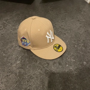 Beige New Era 59FIFTY New York Yankees keps - Jag tycker väldigt mycket om min fitted cap. Har inte haft den så länge, men den är svår att styla för mig  särskilt nu när den inte passar längre efter att jag klippte håret.