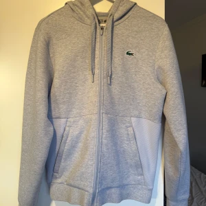 Lacoste kofta/hoodie - Helt ny Lacoste tröja storlek S. Säljer eftersom att den aldrig kom till användning. Skick 10/10. Vid fler frågor och bilder skriv gärna🙏