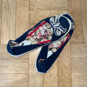 Mörkblå ballerinaskor - Ett par sköna mörkblå ballerinaskor från Z med dekorativ rosett framtill och blommigt innerfoder i rosa och gröna toner. Skorna har en liten defekt på vardera sida men är limmat på plats! Pris går att diskutera! 💙
