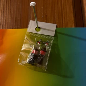 Örhängen med colaflaskor - Unika örhängen formade som små colaflaskor med röda detaljer. Perfekt accessoar för dig som vill sticka ut och visa din lekfulla stil.