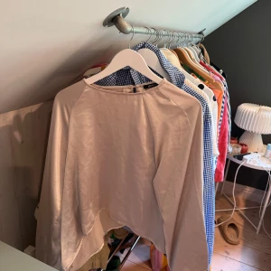 Beige satinblus med vida ärmar - Säljer en beige blus i satin med rund halsringning och vida, långa ärmar. Blusen har en lös passform och ett elegant, glansigt material som ger en lyxig känsla. Perfekt för dig som gillar stilrena och trendiga plagg. Den är lite nopprig men inget som syns så tydligt 