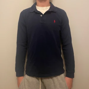 Ralph Lauren pike - Säljer en fet mörkblå pikétröja från Polo Ralph Lauren. Perfekt nu till våren, skriv vid minsta funderingar!