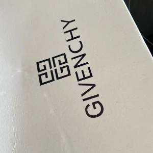 Givenchy skokartong - Vit skokartong från Givenchy med svart logotyp och text på locket. Perfekt för dig som vill ha en exklusiv känsla till dina skor eller behöver en snygg förvaring.