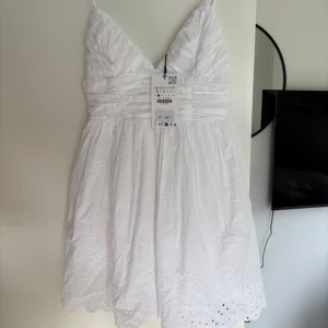 Vit klänning  - Säljer en vit kortklänning med spets detaljer helt oanvänd med lappen kvar köpt från Zara.