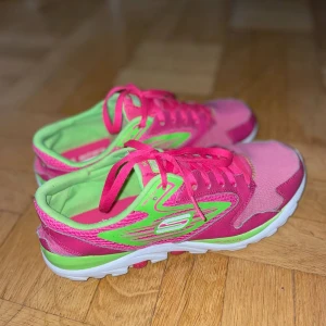 Rosa och gröna Sketchers - Ett par söta färgglada sneakers från Skechers GoRun i rosa och limegrönt med vita sulor. Skorna har snörning och har mjukt tygmaterial! 🩷💚🤍