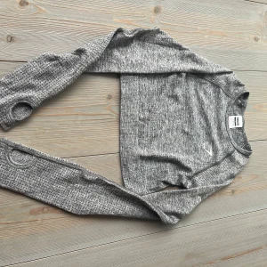 Grå långärmad träningströja från Gymshark - Säljer en gråmelerad långärmad träningströja från Gymshark. Tröjan är croppad och har tumhål i ärmsluten. Perfekt för gymmet eller löpning. Materialet är syntet och sitter tight mot kroppen.Gymshark marble grey vital seamless top, oanvänd. Säljs inte längre! Storlek: xs  Kika gärna in på mina andra annonser, säljer fler träningskläder  och kan samfrakta!