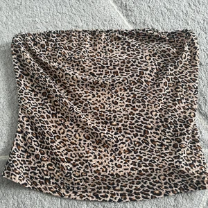 Leopardmönstrad tubtopp - Säljer en snygg tubtopp med leopardmönster. Toppen är ärmlös och har en tight passform, perfekt för att skapa en trendig look. Materialet är mjukt och stretchigt för extra komfort.