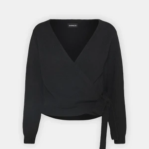 Svart omlottkofta från even&odd - Säljer en svart omlottkofta från even&odd med knyt i sidan och v-ringad hals. Koftan har långa ärmar och ribbade muddar. Perfekt att slänga på sig för en stilren look.