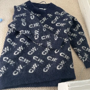 Mörkblå stickad tröja från Carin Wester - Mysig mörkblå stickad ulle tröja från CW med vitt mönster över hela tröjan. Tröjan har lång ärm och rund halsringning. Perfekt för kyligare dagar och enkel att styla till olika outfits.