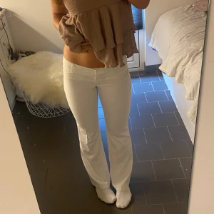 Vita kostymbyxor från Vero Moda - Snygga vita kostymbyxor från Vero Moda med raka ben och diskreta fickor bak. Byxorna har normal passform och är perfekta för en stilren look. Klassisk design som passar till många olika outfits.