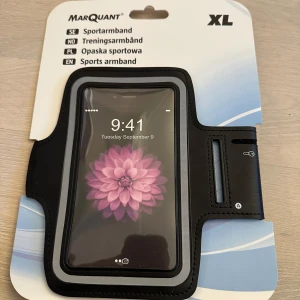 Svart sportarmband från Marquant XL - Sportarmband i svart med transparent fönster för mobil, justerbart kardborreband och öppning för hörlurar. Perfekt för att ha mobilen med sig under träning. Passar större mobiler och har en smidig design.