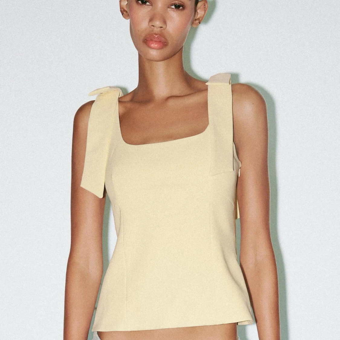 Ljusgul topp med rosetter på axelbanden - 4