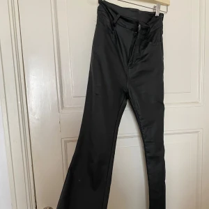 Svarta bootcut byxor i glansigt material  - Garderobsrensning pågår! 👗 Shoppa loss bland en massa fina plagg. Kika in på min sida, så kanske du hittar något mer du gillar!  Har du frågor om ett plagg? Tveka inte att höra av dig!  (OBS: Kan tyvärr inte ta bilder med plaggen på.)
