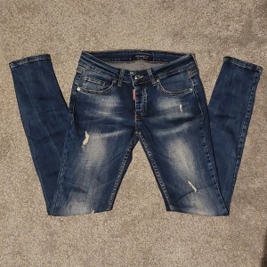 Dsquared2 Jeans - Säljer ett par blå jeans från Dsquared2 med slitna detaljer passar för dom som är 9-11 år