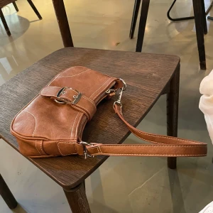 Brun axelväska  - så snygg brun väska med silvriga metalldetaljer 