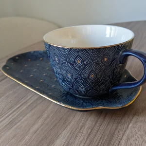 Kopp med fat från Indiska  - En vacker kopp med fat i blått och guldmönster från Indiska. Perfekt för te eller kaffe och en snygg detalj till köket eller fikastunder. 