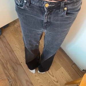 Svarta bootcut jeans - Säljer ett par svarta bootcut jeans med klassisk femficksdesign och gylf med dragkedja och knapp. Jeansen har en något utsvängd passform nertill och är perfekta för dig som gillar en tidlös stil. Passar mig som är s/M och är 168cm