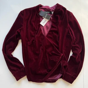 Vinröd omlottblus i sammet från Lauren Ralph Lauren - Säljer en lyxig vinröd omlottblus i sammet från Lauren Ralph Lauren. Den är i storlek xs och aldrig använd med lapparna kvar, nypris är 2500kr. Priset går att diskutera🥰🥰 