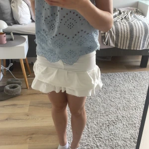 Vit volangkjol - Säljer en söt vit kortkjol med volangdetaljer. Kjolen har en figurnära passform upptill och volanger nedtill som ger en lekfull look. Perfekt för varma dagar och enkel att matcha med olika toppar. Kjolen är sydd av ett par gamla lager 157 byxor. Pris går att diskutera 💕