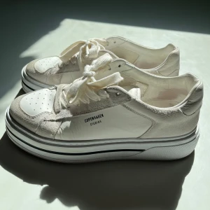 Vita sneakers från Copenhagen Studios - Säljer ett par vita sneakers från Copenhagen Studios med chunky sula och snygga detaljer i mocka och skinn. Storlek 39 dem har varit väl omhändertagna, nypris över 2000 kr🌸