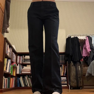 Mörkblå jeansbyxor från Lee - Mörkblå byxor från Lee. Ser ut som jeans men har ganska mycket stretch i materialet. Med presssveck! Lågmidjade (eller typ mid Rise) och utsvängda. Saknar nederkantssöm men fint skick annars.   Ungefärliga mått: Midja platt: 40cm Innerben: 80cm Hel längd: 105cm