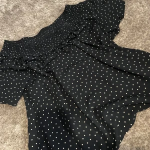 Mörkblå prickig offshoulder topp från Bik Bok - Mörkblå offshoulder topp från Bik Bok med vita prickar. Toppen har smock upptill och korta ärmar. Lätt och luftig i materialet. Priset går att skjustera🩵