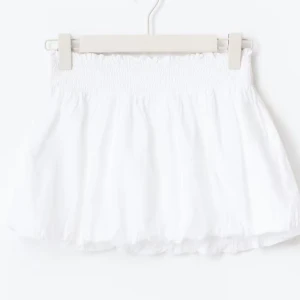 Vit ballon kortkjol med prislapp  - Säljer en söt vit kortkjol med smock i midjan. Kjolen har en luftig och lätt känsla, perfekt för varma dagar. Enkel att matcha med olika toppar och skor för en fräsch look. storlek 170 i gina young