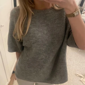 Populär grå stickad tröja med kort ärm från lager 157 - Säljer den trendiga grå stickade tröjan från lager 157 då den tyvärr inte kommer till användning längre. Superbra skick och den är såå mjuk och skön. Lappen har tyvärr trillat av och minns inte riktigt storleken men xs eller s