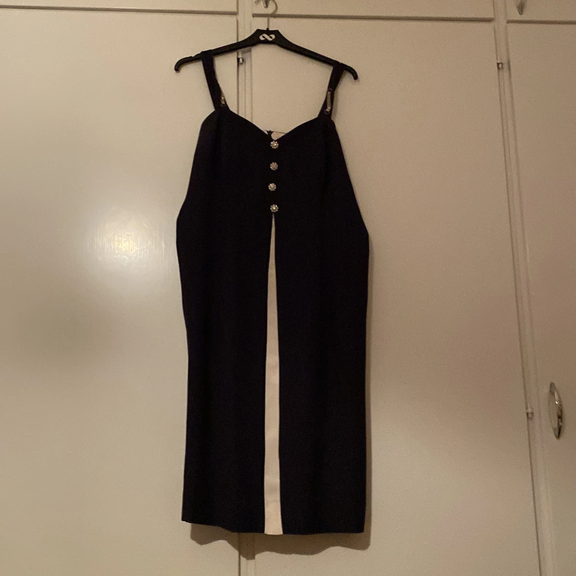 Svart klänning med knappar och axelband