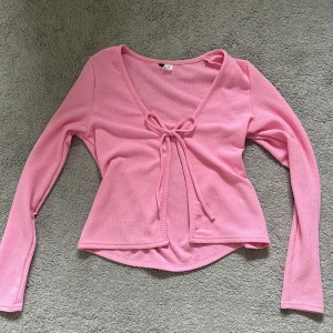 Rosa tröja med knyt - Säljer en söt rosa tröja med lång ärm från Hm Divided.💕 storlek M men passar mig bra som har storlek S, köpt secondhand men i super bra skick och jag har aldrig använt den bara prövat