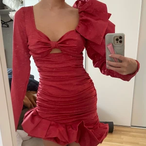 Rosa miniklänning med volang och rosett - Så cool och unik klänning från pretty little thing med lapparna kvar, perfekt för en tema fest eller liknande😍