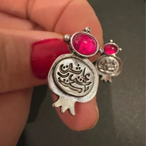 Granatäppleformade örhängen med röd sten - Unika örhängen i form av granatäpplen med ingraverad text och en oval röd sten upptill., perfekta för att ge en färgklick till din stil.