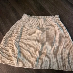 Beige stickad kjol - Mysig beige stickad kjol med bred resår i midjan och ribbad struktur. Kjolen har en lätt utställd form och är perfekt för dig som gillar en enkel men trendig look. Lappen är klippt så har ingen aning vart jag har köpt den, storlek xs men passar S med🌸
