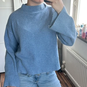 Blå stickad tröja med vida ärmar - Mysig blå stickad tröja med hög ribbad krage och vida, långa ärmar!!