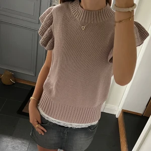 Rosa/lila stickad tröja  - Kortärmad stickad tröja med volanger från Lindex i fint skick. Kan inte hitta storlek men skulle säga S/M. Använd gärna köp nu!