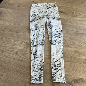 Svarta och vita leggings med mönster - Snygga leggings i vitt med svart abstrakt mönster. De har en tight passform och är perfekta för dig som vill sticka ut lite extra. Materialet känns mjukt och stretchigt, vilket gör dem bekväma att bära hela dagen.
