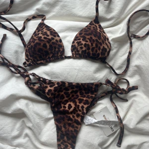 Leopardmönstrad bikini från Calzedonia - Trendigt leopardmönstrad bikini från Calzedonia med trekantsöverdel och knyt i sidorna på både topp och trosa. Snygga bruna och svarta toner, perfekt för stranden. Överdelen är använd en gång så den har inte lapparna kvar men underdelen är oanvänd och har lappar kvar⭐️🩷