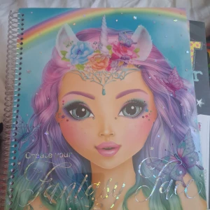 Fantasy Face (FANTASYModel) - Skapa magiska och fantasifulla ansikten med denna kreativa bok! Innehåller mallar, klistermärken och inspiration för att designa egna fantasylooks. Perfekt för dig som älskar konst, smink och att uttrycka din kreativitet. Har flera stycken olika Topmodel  böcker så det är bara att höra av sig om man är intresserad☺️