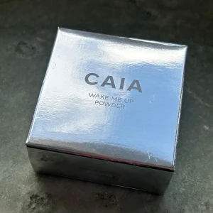 CAIA Wake Me Up Powder - Endast sparsamt testad vid ett tillfälle - men nyansen passade tyvärr inte mig. Nyansen ”Banana”  ”Ett mjukt löspuder som ljusar upp och smälter in i huden tack vare sin transparenta täckning. Wake Me Up är speciellt utvecklad för området runt ögonen och har en skimrig formula som ger en uppljusande effekt. Pudret innehåller hyaluronsyra som har återfuktande egenskaper och gör att produkten blir ett med huden.”  Nypris 249kr.