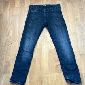 Svarta  Slim/Glenn jeans från Jack & Jones - Säljer ett par svarta  Slim/Glenn jeans från Jack & Jones i storlek 31/30. Jeansen har en slim passform, klassisk femficksdesign och snygg tvätt med lätt slitning. Perfekta för dig som gillar en smalare siluett och stilren look.