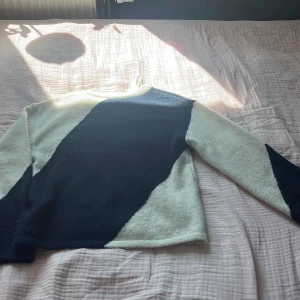 Randig stickad tröja från Gina Tricot - Säljer en stickad tröja från Gina Tricot i storlek 158/164. Tröjan har ett coolt diagonalt randigt mönster i svart och vitt, med rund halsringning och långa ärmar. Perfekt för dig som gillar en stilren men ändå unik look.
