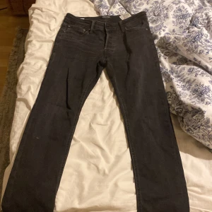 Svarta raka jeans  - Säljer ett par svarta jeans med rak passform och klassisk femficksdesign. Jeansen har normal midja och är tillverkade i ett mjukt bomullsmaterial med lite stretch för extra komfort. Perfekta till sneakers eller boots.