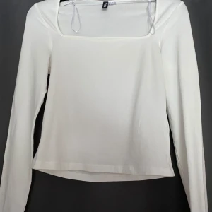 Vit långärmad topp från H&M Divided - Vit långärmad topp från H&M Divided med fyrkantig ringning. Enkel och stilren design som passar perfekt till jeans eller kjol. Mjuk och stretchig bomullsblandning för en bekväm känsla hela dagen. Storleken tycker jag inte känns som S, jag tycker det känns mer som XS
