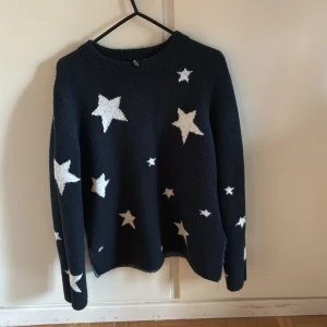 Mörkblå stickad stjärntröja Divided XS - Mysig mörkblå stickad tröja från Divided i storlek XS. Tröjan har vita stjärnor över hela och en klassisk rund halsringning. Perfekt för dig som gillar en cool och lekfull stil. Långärmad och skön att bära under kyliga dagar.