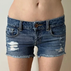 Lågmidjade jeansshorts med hål American eagle vintage 2000s  - Shorts från american eagle. Uppskattad storlek S. Eller w27-w28. Midjemått: 39. Köp sker via köp nu, jag postar inom 24h. Kvar tills markerad såld.