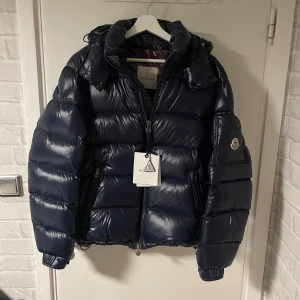 Moncler Maya - Tja! Säljer nu min Moncler Maya i nyskick i färgen marinblå i storlek 3 som motsvarar storlek L, den är i ny skick inga skador på den, tags medförljer, kan användas på vår höst vinter, han på bilden är 179cm, skriv om ni har några frågor eller funderingar!! OBS kom med bud( rimliga bud!!!!)